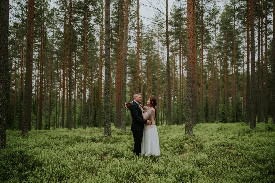 Hääpari metsässä, kaukaa kuvattu