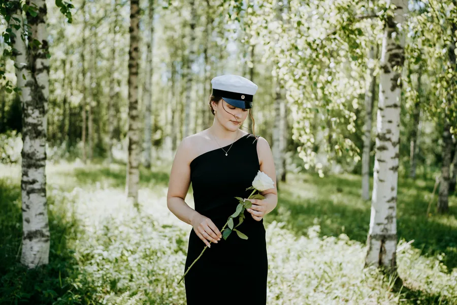 Ylioppilas lakki päässä koivumetsässä