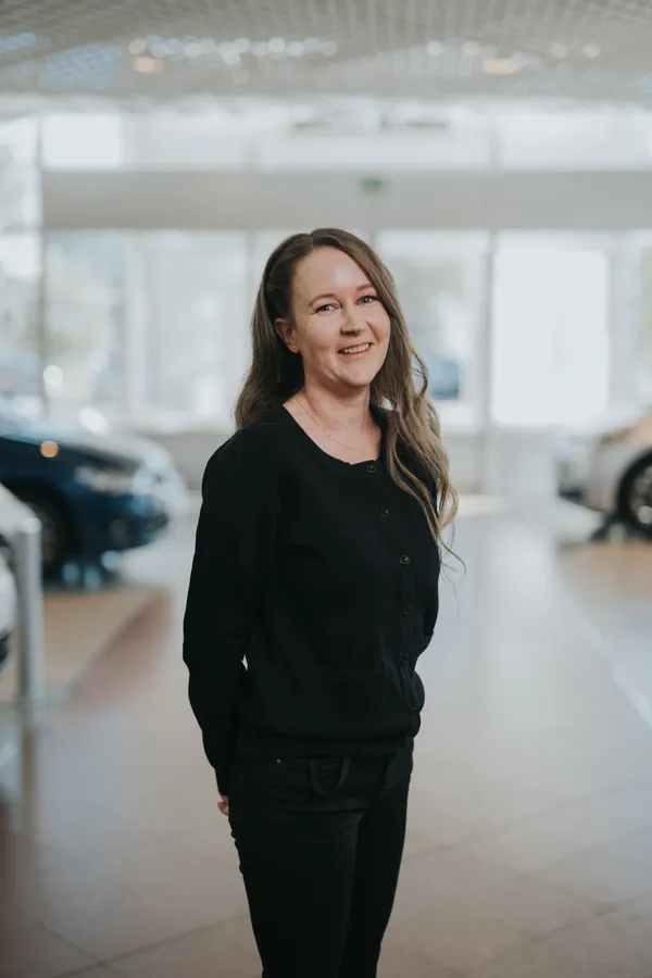 Hymyilevä nainen autoliikkeessä